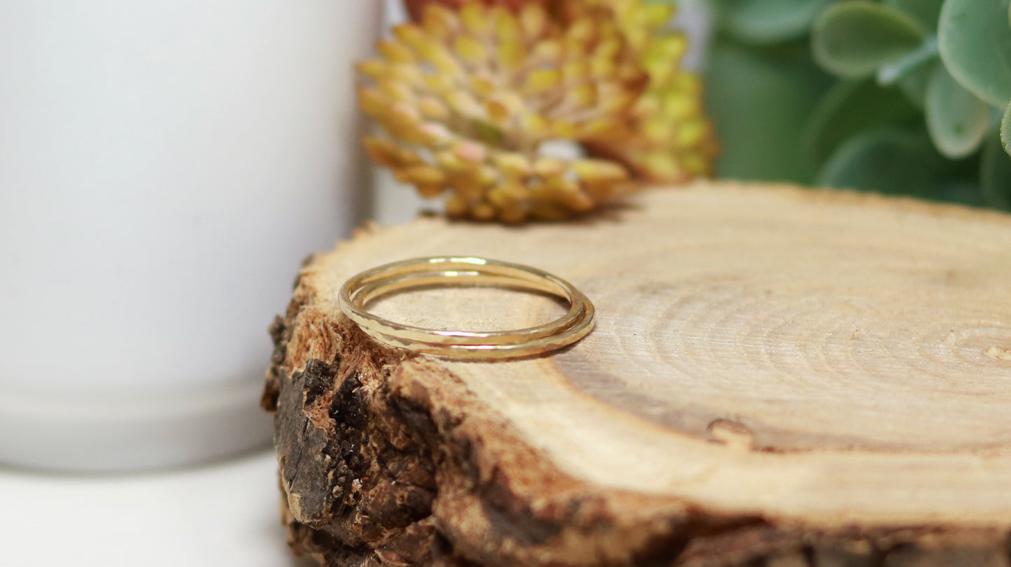 Thin yellow gold stacking rings with a hammer texture.