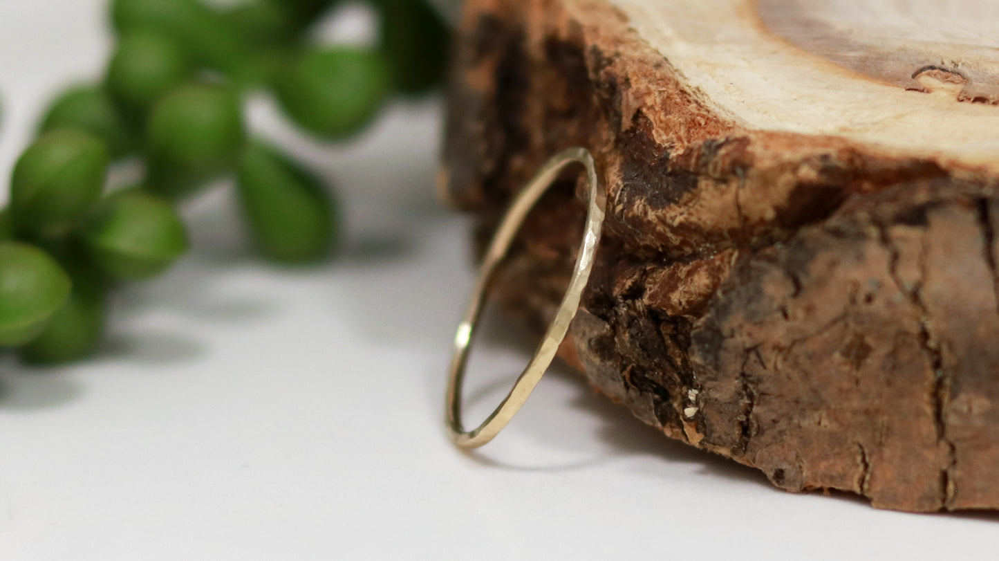 Thin yellow gold stacking rings with a hammer texture.