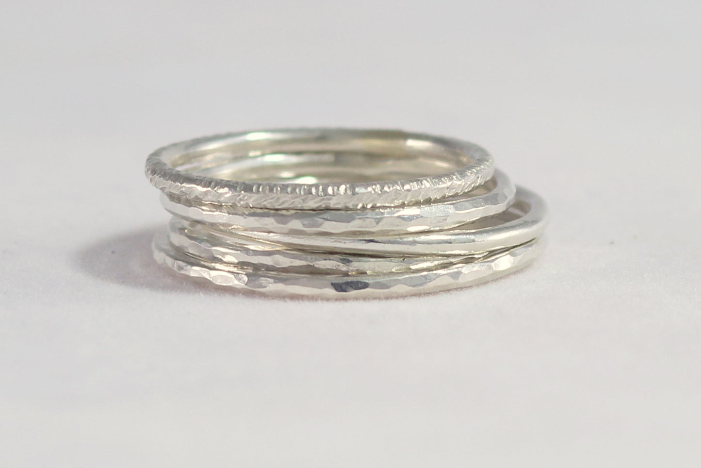 Thin sterling silver stacking rings with a hammer texture.