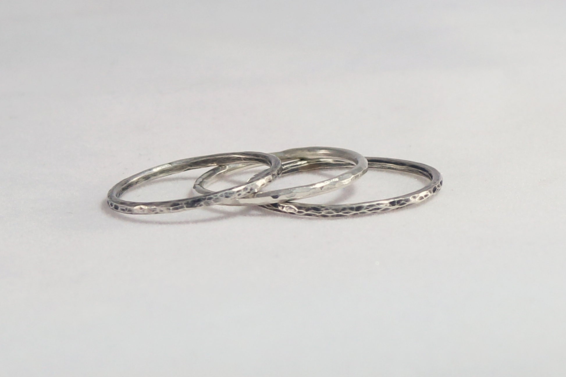 Thin sterling silver stacking rings with a hammer texture.