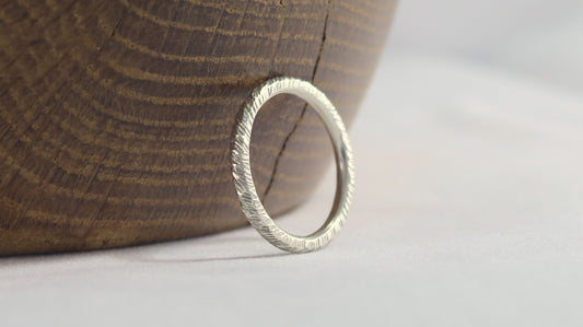 A thick sterling silver ring band with a rough hammer texture. 