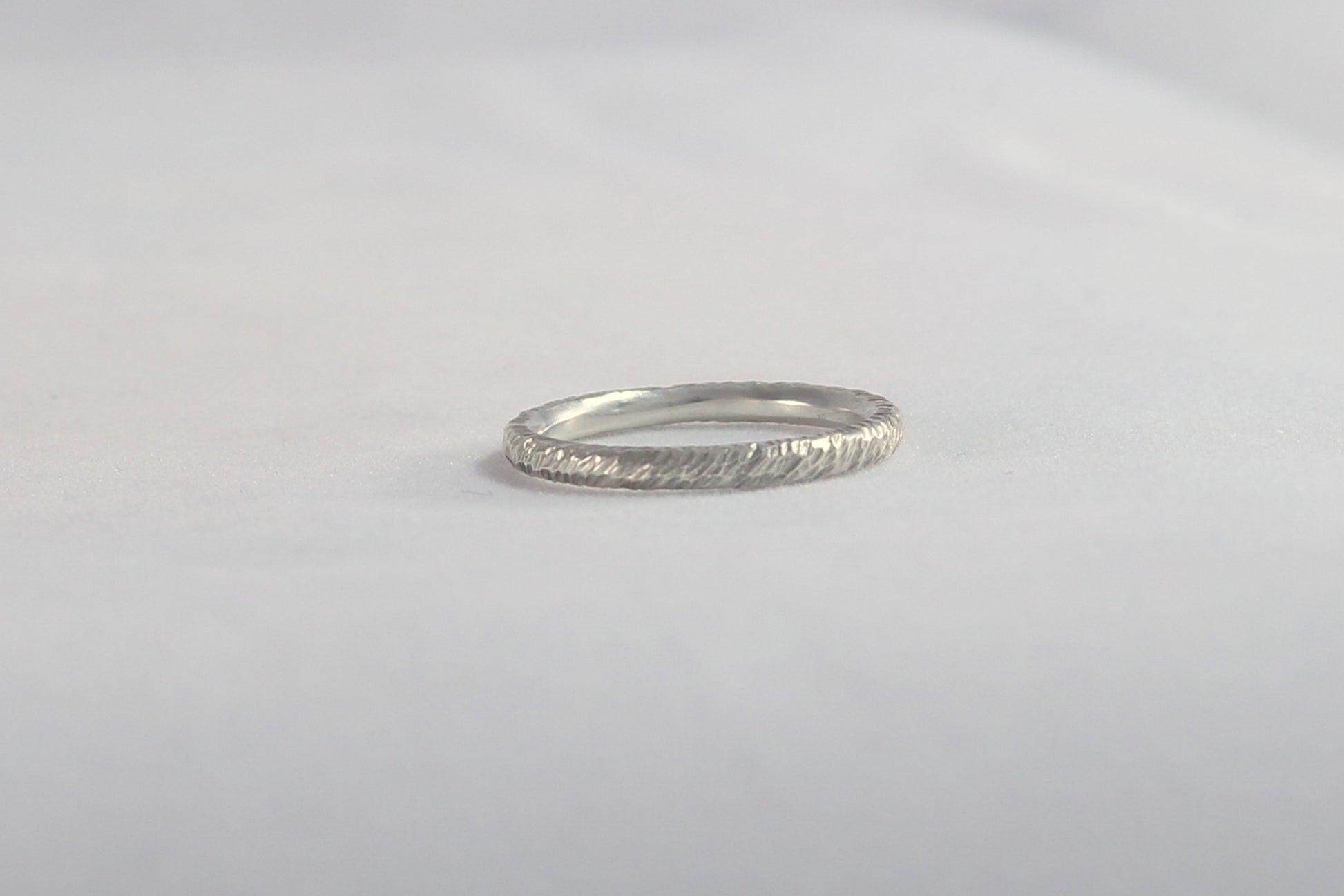 A thick sterling silver ring band with a rough hammer texture. 