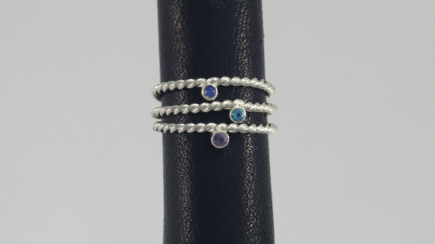 Round natural gemstone set in a sterling silver bezel on a twisted sterling silver ring band.