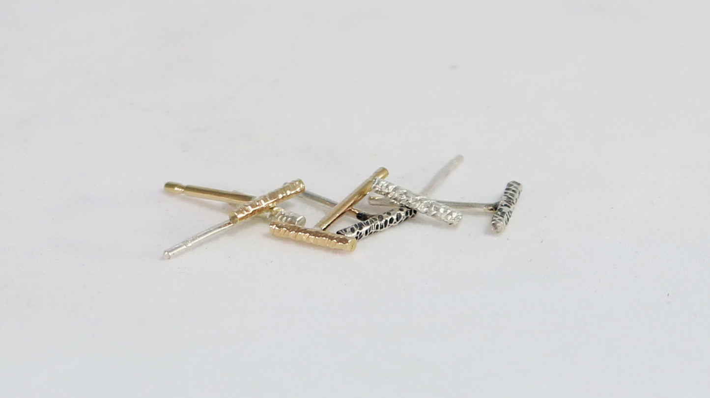 14k yellow gold silver bar studs with a rough hammer texture.
