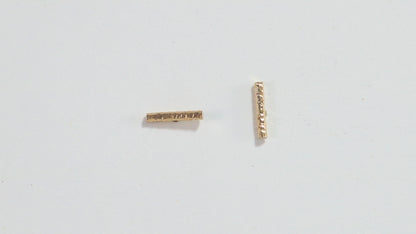 14k yellow gold bar studs with a rough hammer texture.