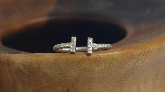 Sterling silver open bar ring with vertical bars on each side, textured with a rough hammer.