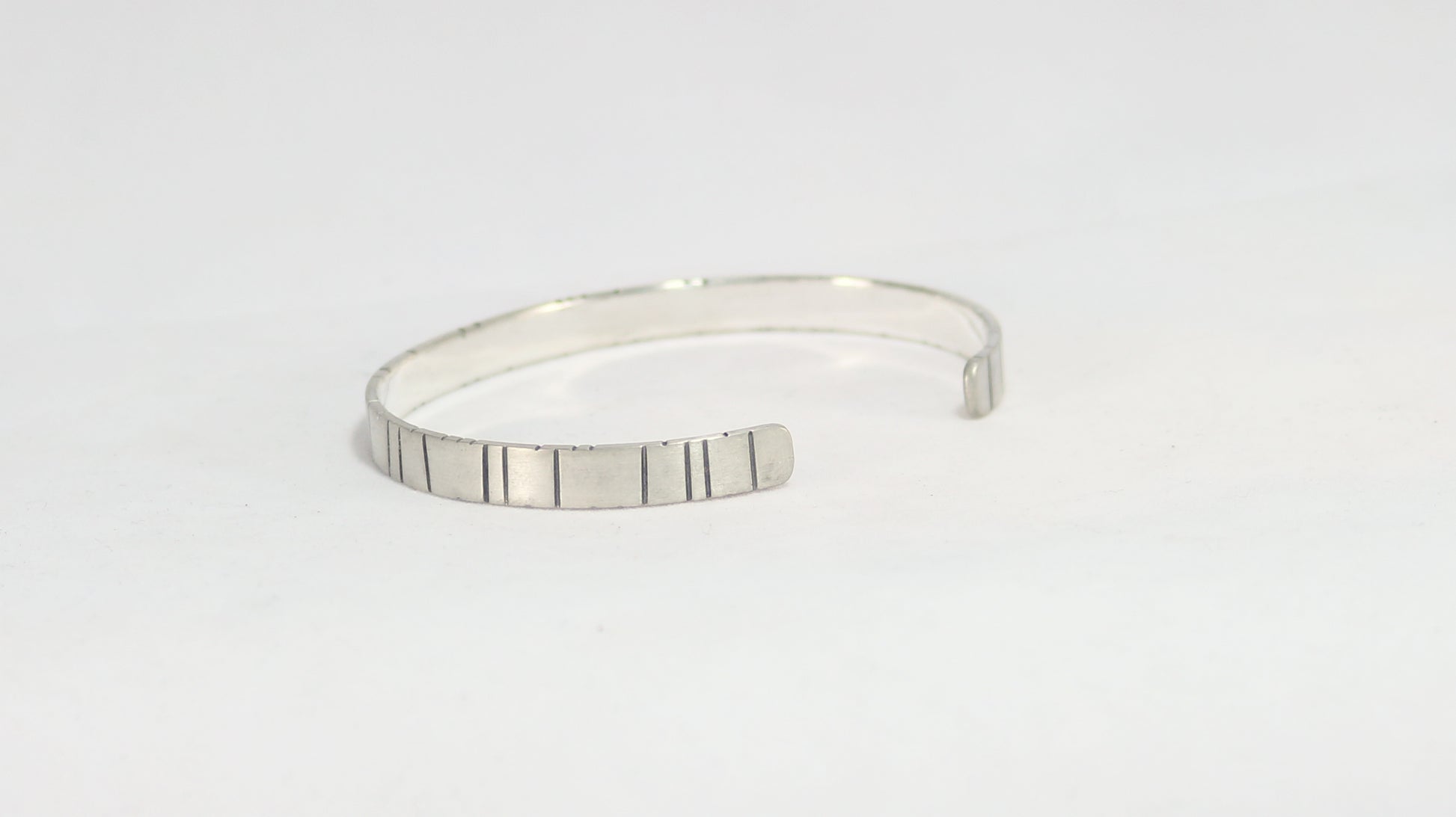6mm sterling silver cuff with randomly spaced black lines.