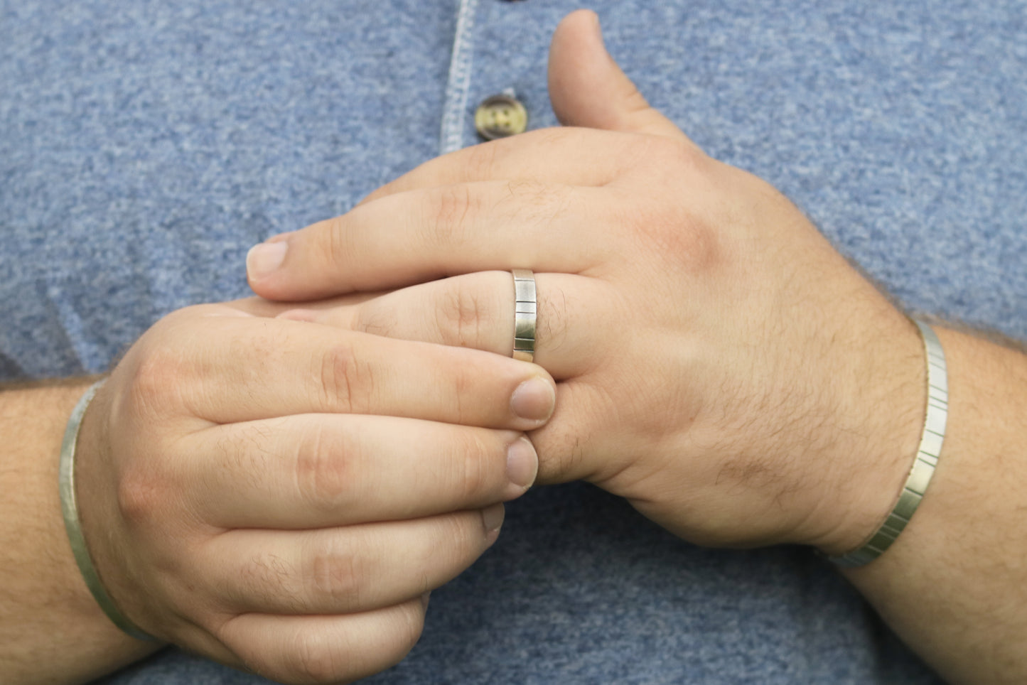 A model wearing a 6mm thick silver ring band with randomly spaced black line details.