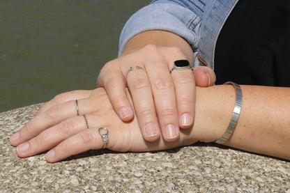 A model wearing Thin sterling silver stacking rings with a hammer texture.