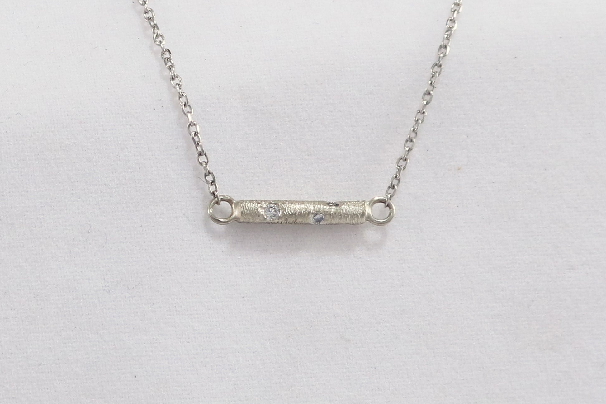 Solid 14k gold bar necklace, textured and set with 6 diamonds.