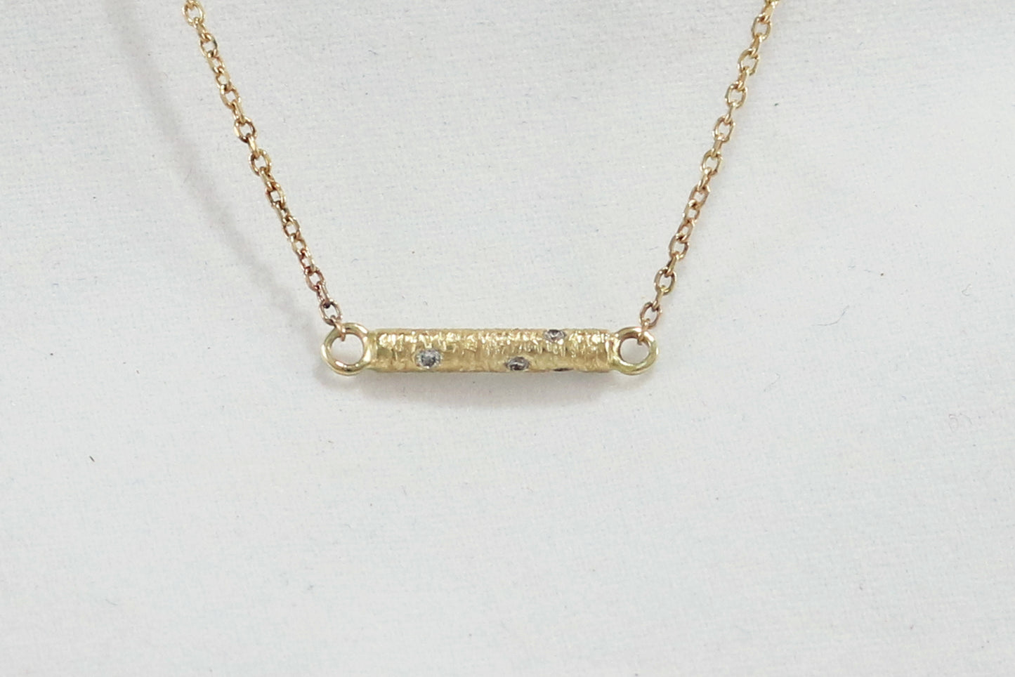 Solid 14k gold bar necklace, textured and set with 6 diamonds.