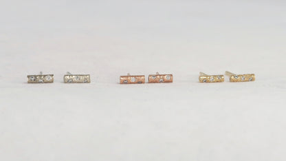 Solid 14k gold bar studs, textured and set with 3 diamonds in each.