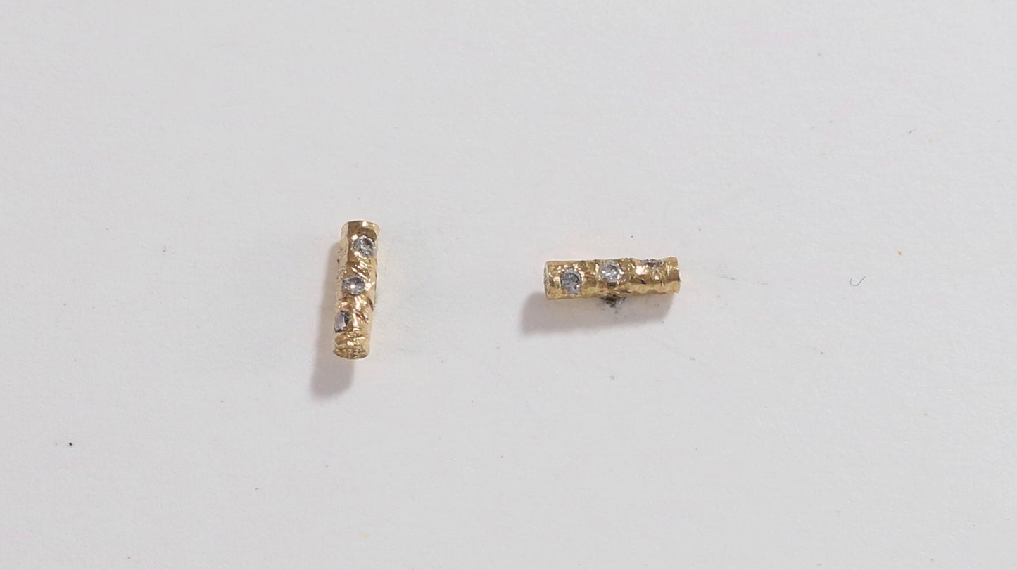 Solid 14k gold bar studs, textured and set with 3 diamonds in each.