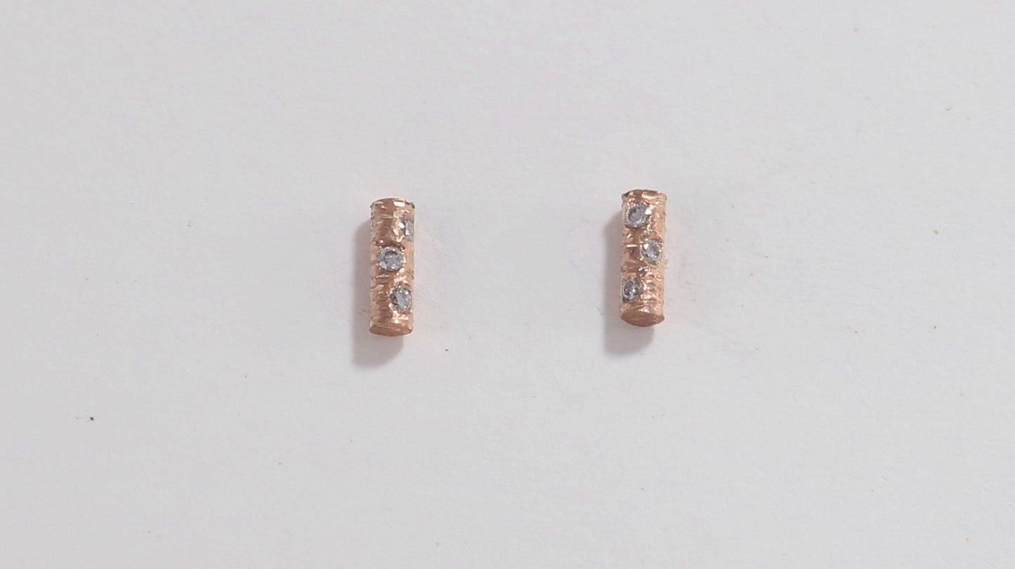 Solid 14k gold bar studs, textured and set with 3 diamonds in each.