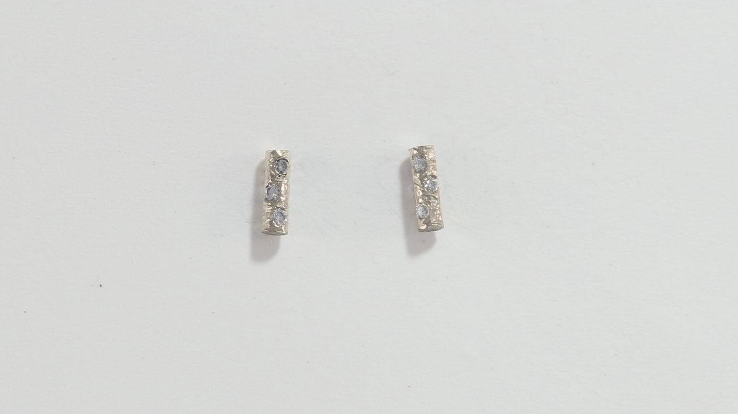 Solid 14k gold bar studs, textured and set with 3 diamonds in each.