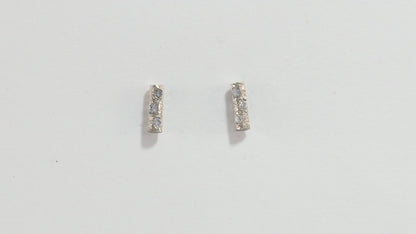 Solid 14k gold bar studs, textured and set with 3 diamonds in each.