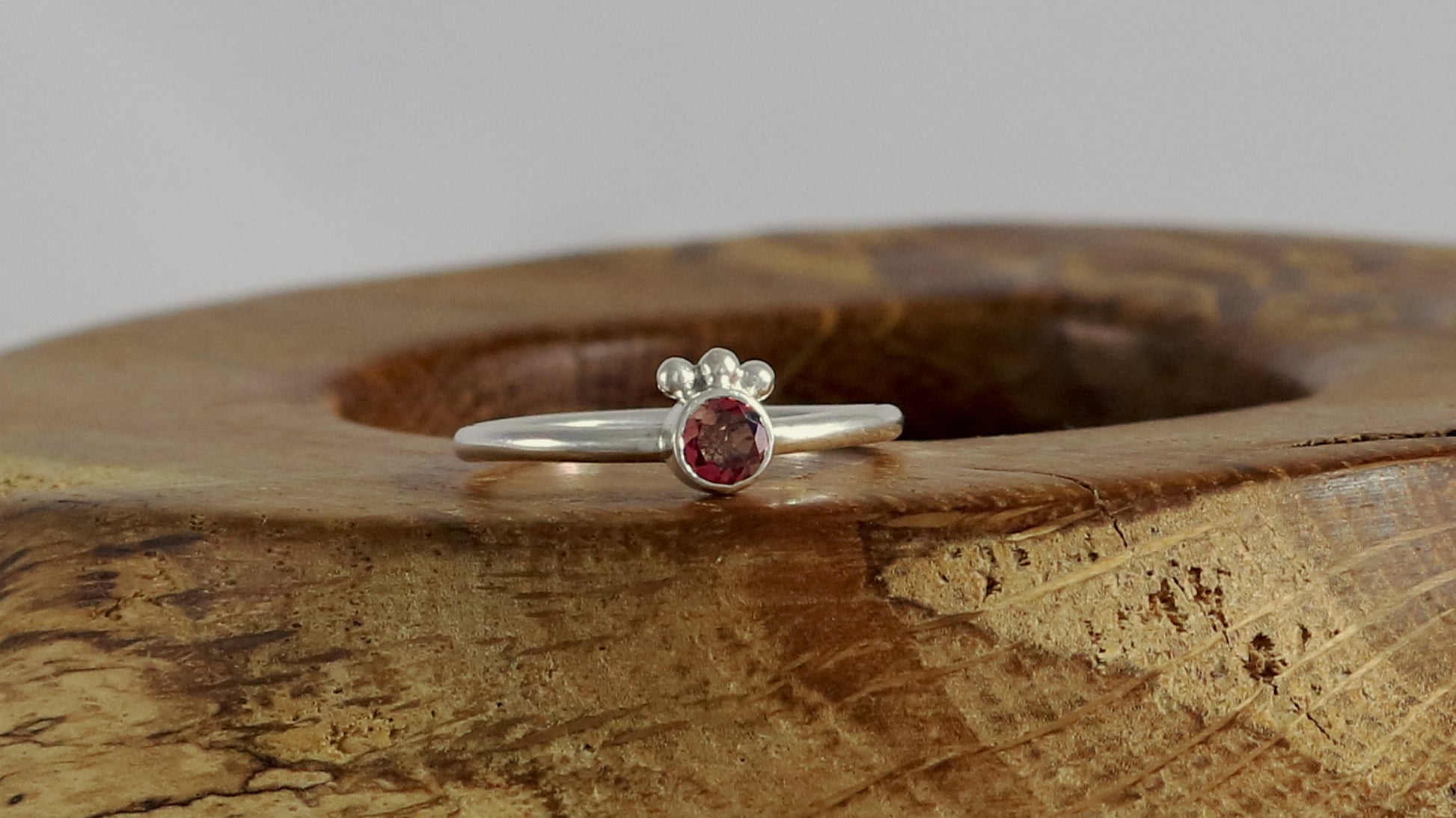 Natural rose quartz gemstone set in sterling silver bezel, 3 silver bubble accents along bezel on sterling silver ring band.