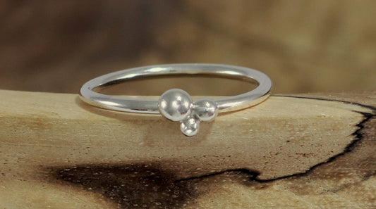 Three sterling silver bubbles in a pyramid on a sterling silver ring band.