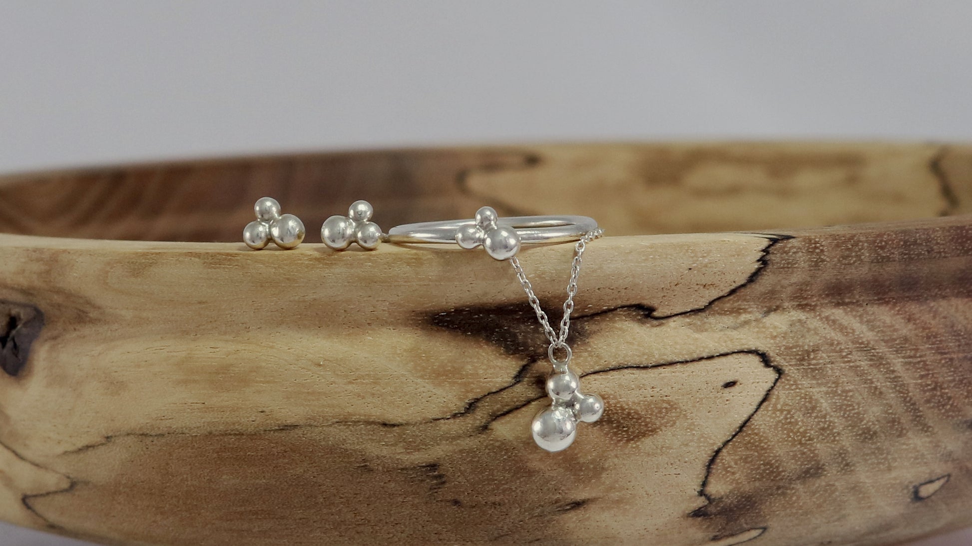 Three sterling silver bubbles in a pyramid on a sterling silver chain.