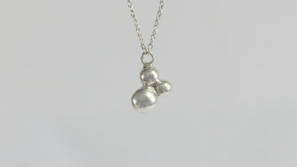 Three sterling silver bubbles in a pyramid on a sterling silver chain.