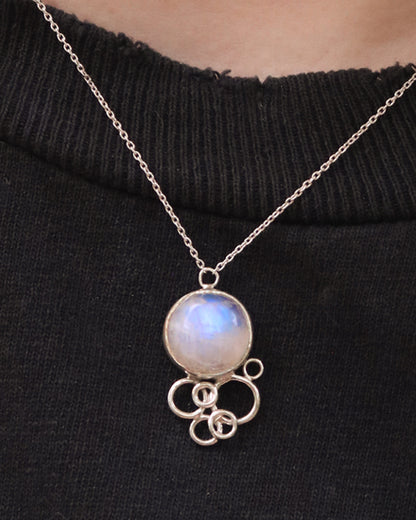 Natural round rainbow moonstone on a silver chain, with 6 silver open circles placed below to look like a cluster of bubbles.