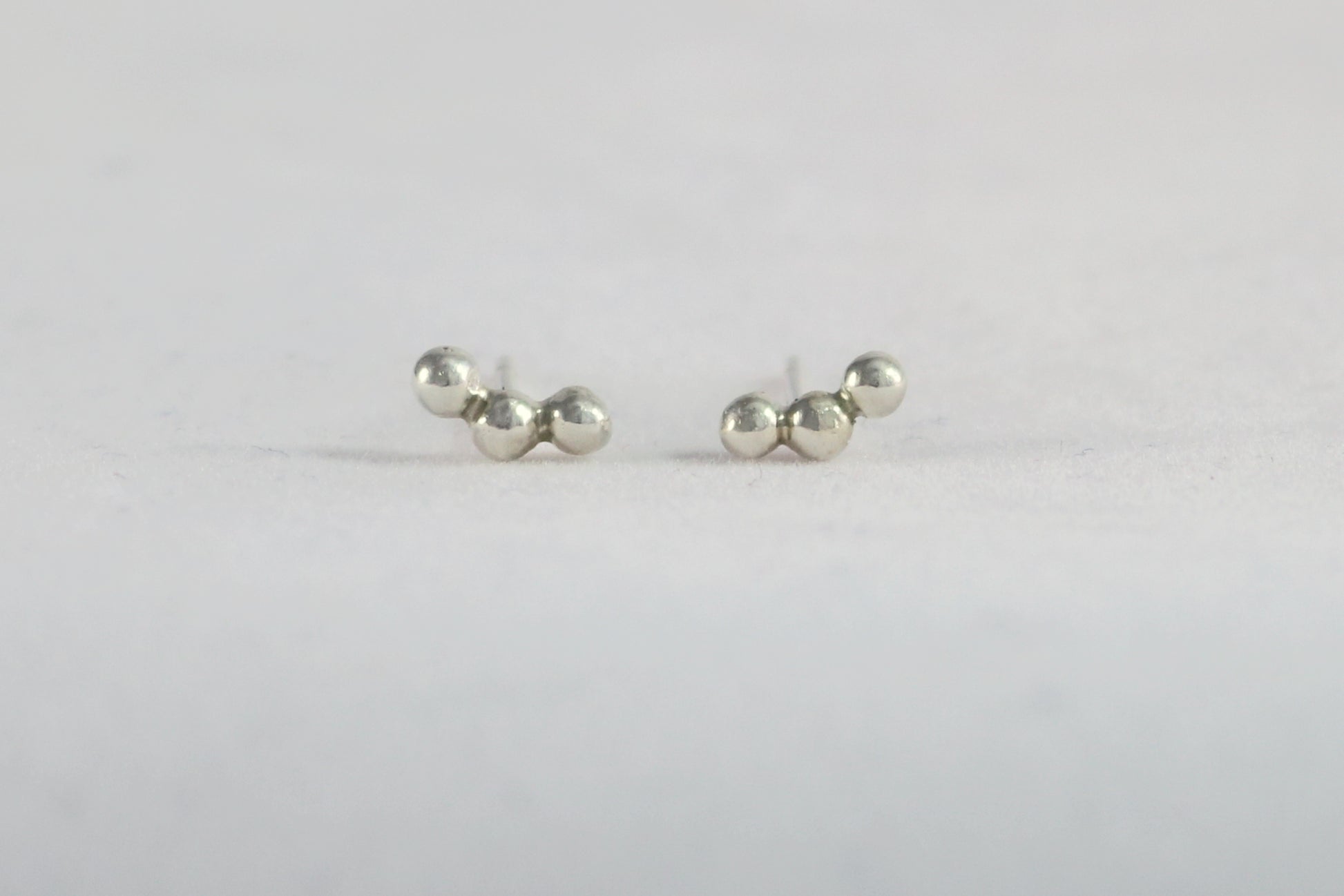 Sterling silver studs with three bubbles along a curve.