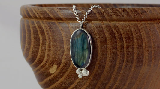 Oval natural Labradorite gemstone set in sterling silver bezel with 4 bubble cluster accent on a sterling silver chain.