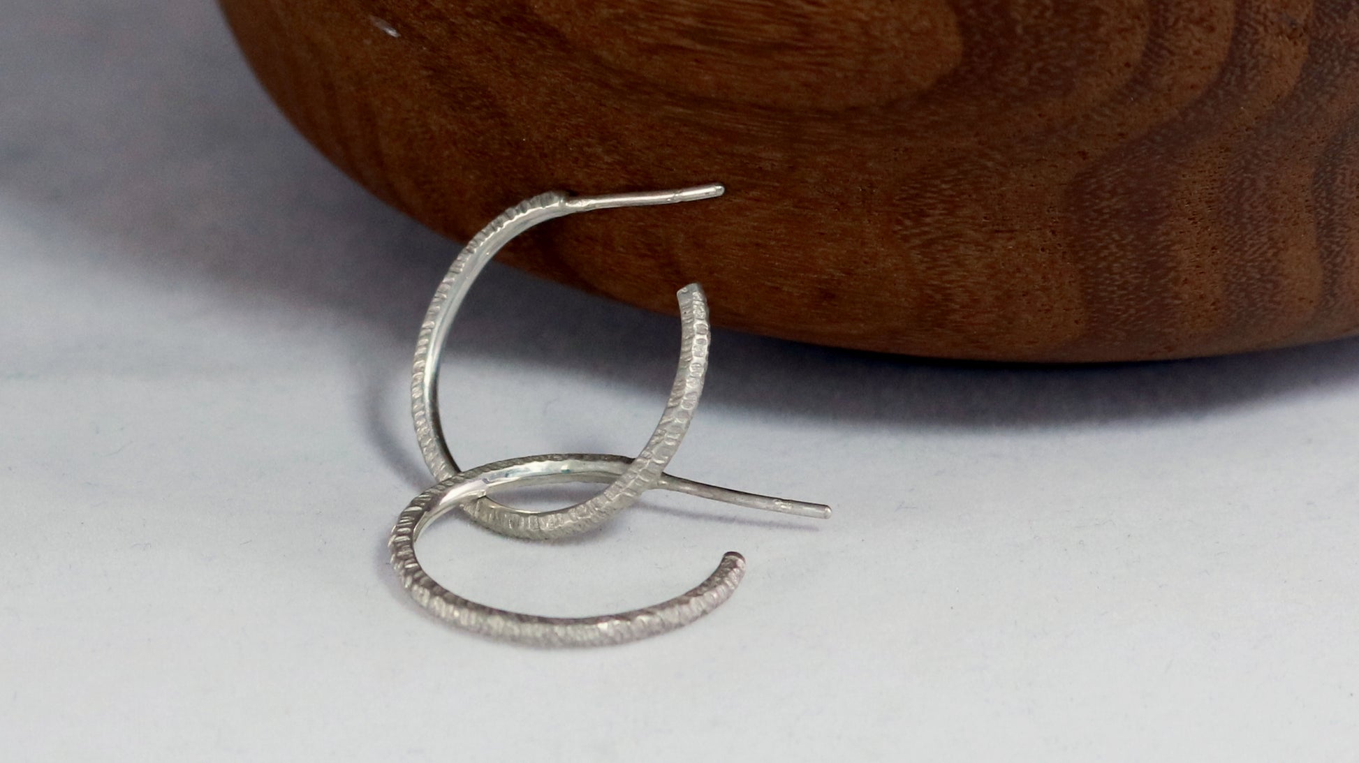 1 inch sterling silver hoops with a rough hammer texture.