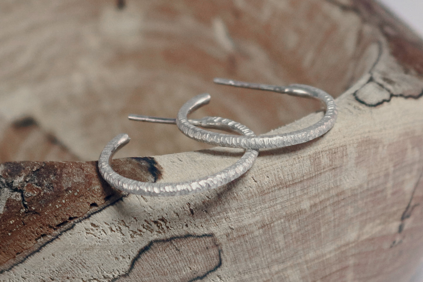 1 inch sterling silver hoops with a rough hammer texture.