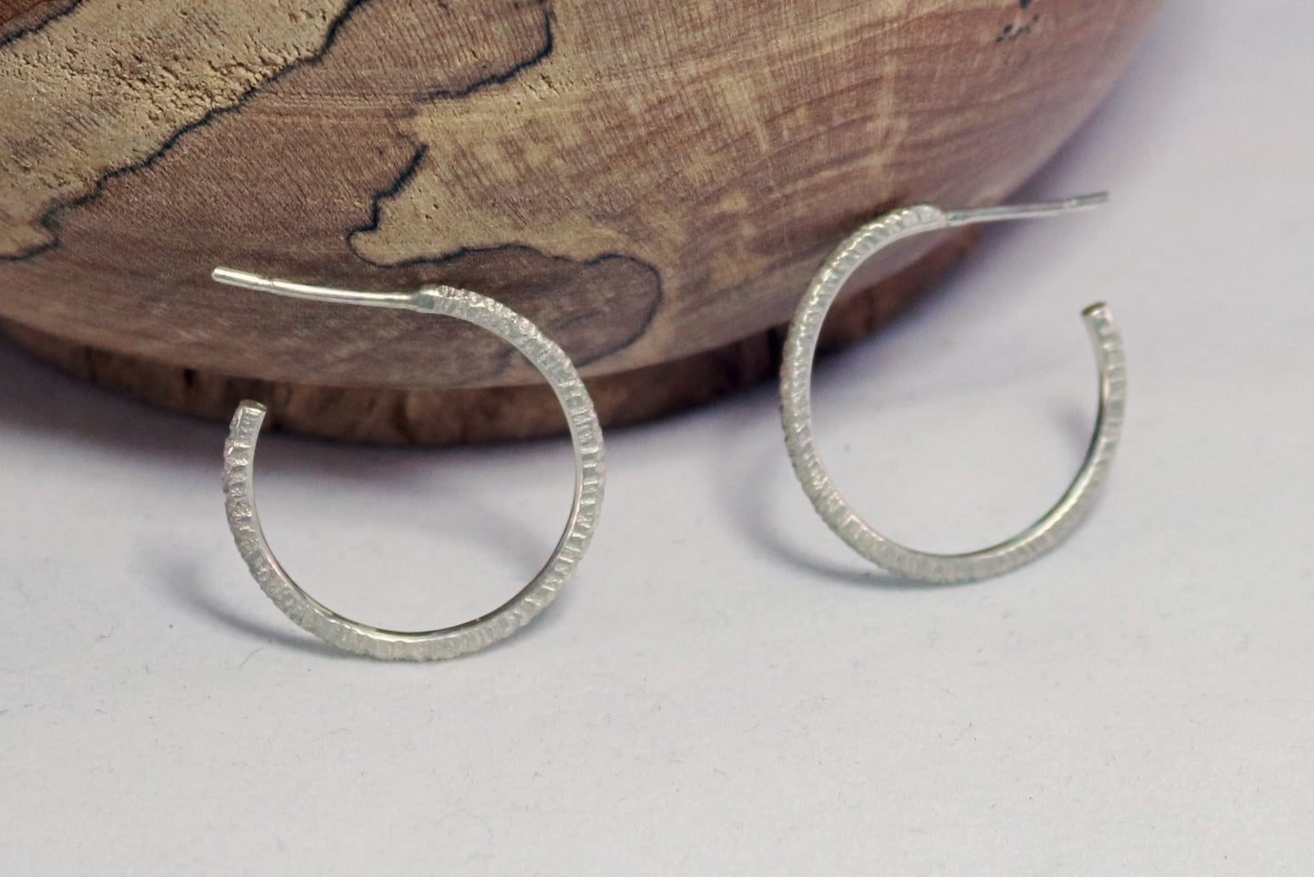 1 inch sterling silver hoops with a rough hammer texture.