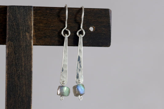 A hand forged, textured, sterling silver, elongated drop with a hanging labradorite bead.