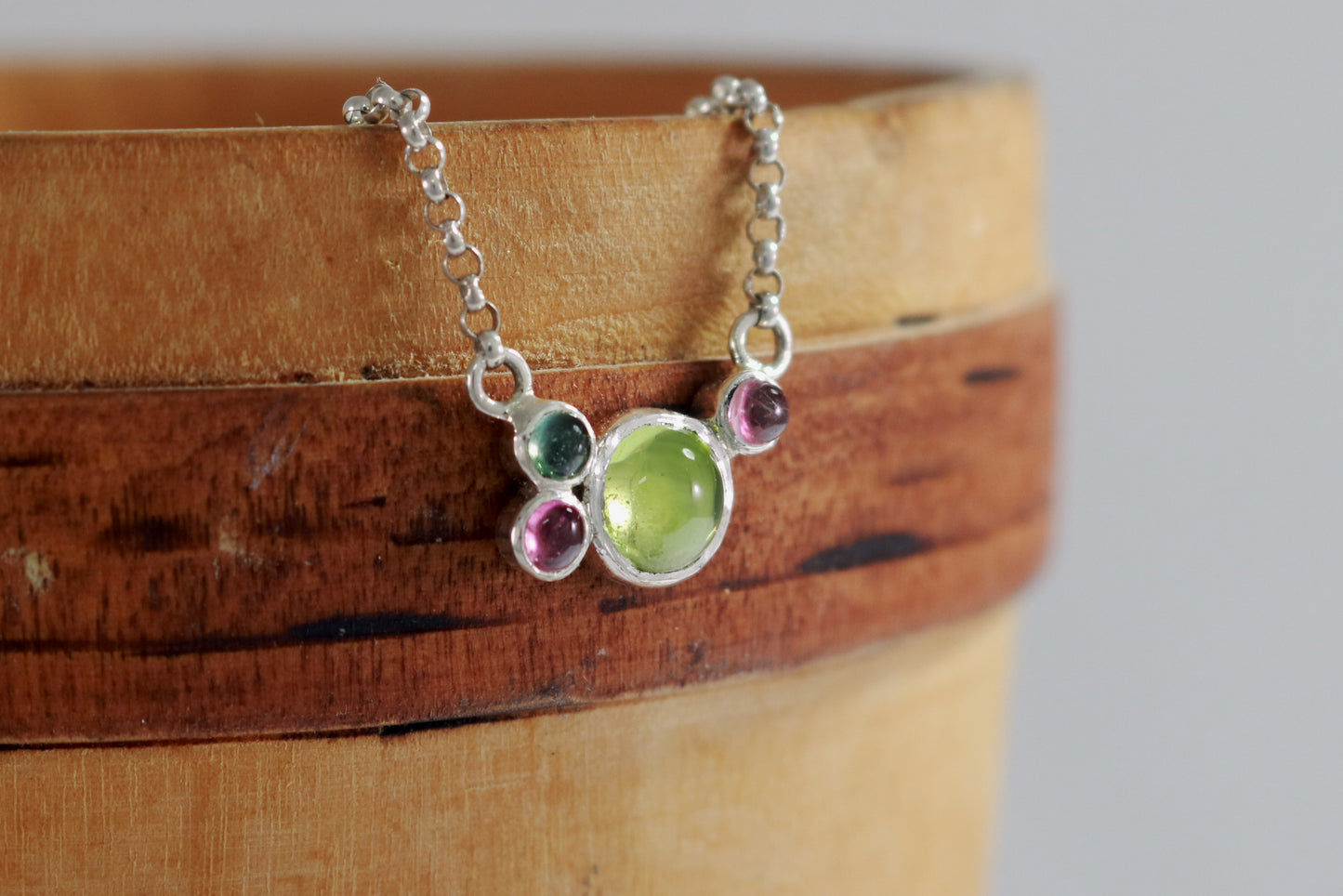 Round natural peridot & tourmaline gemstones set in  sterling silver in a cluster on a sterling silver chain.