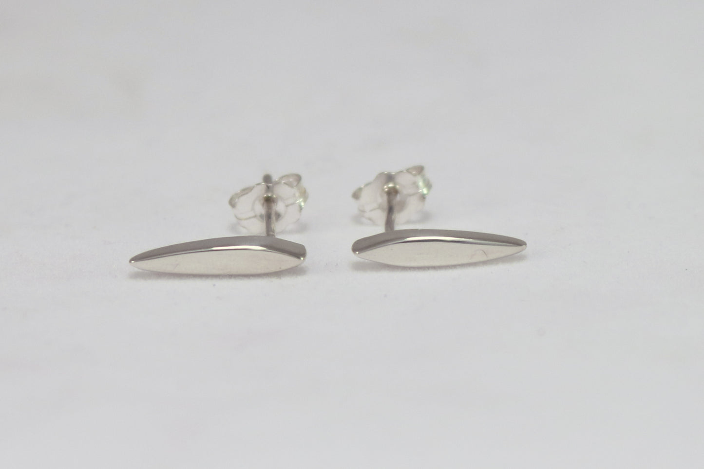 Studs made from solid sterling silver, shaped like a pointed ellipse.