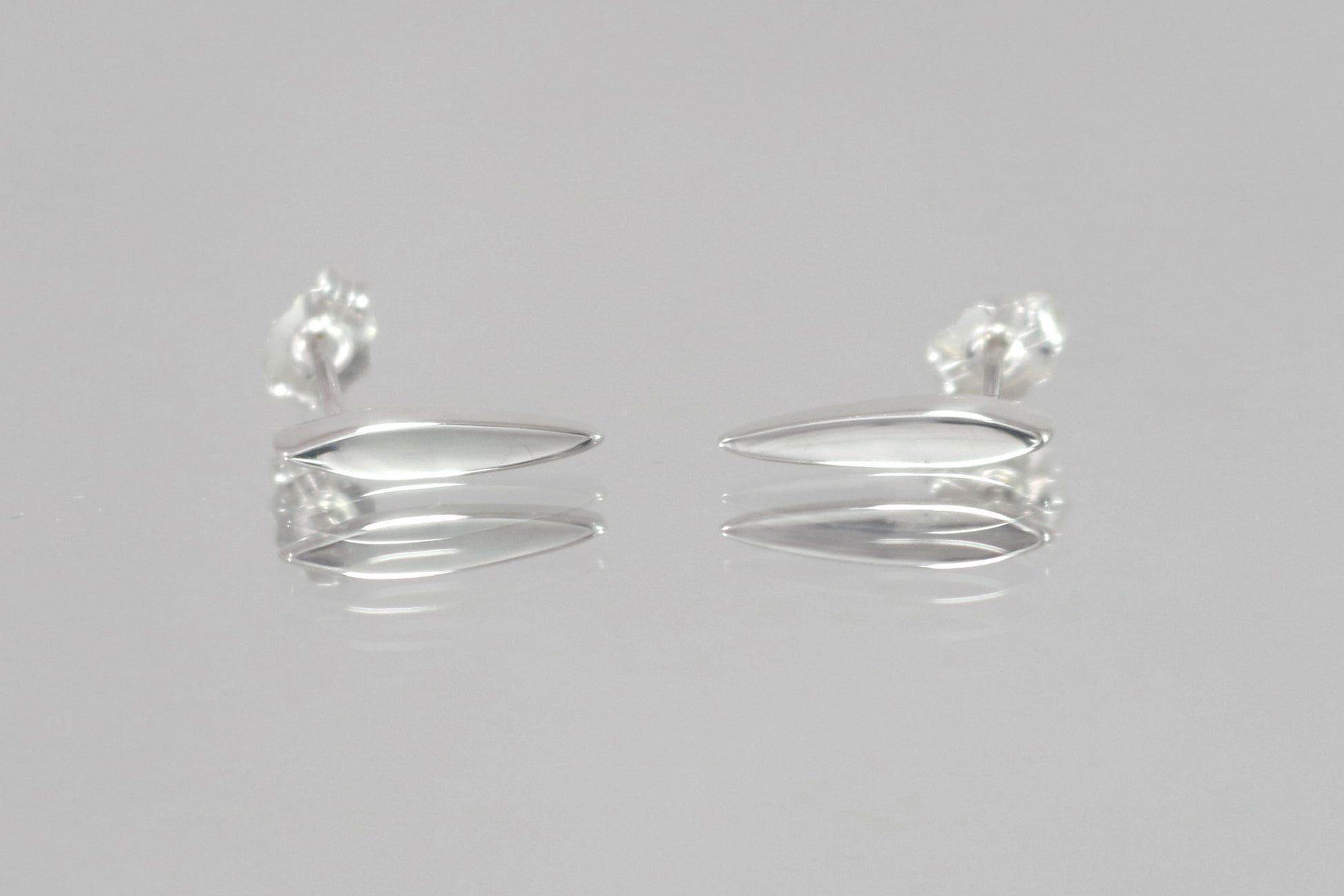 Studs made from solid sterling silver, shaped like a pointed ellipse.