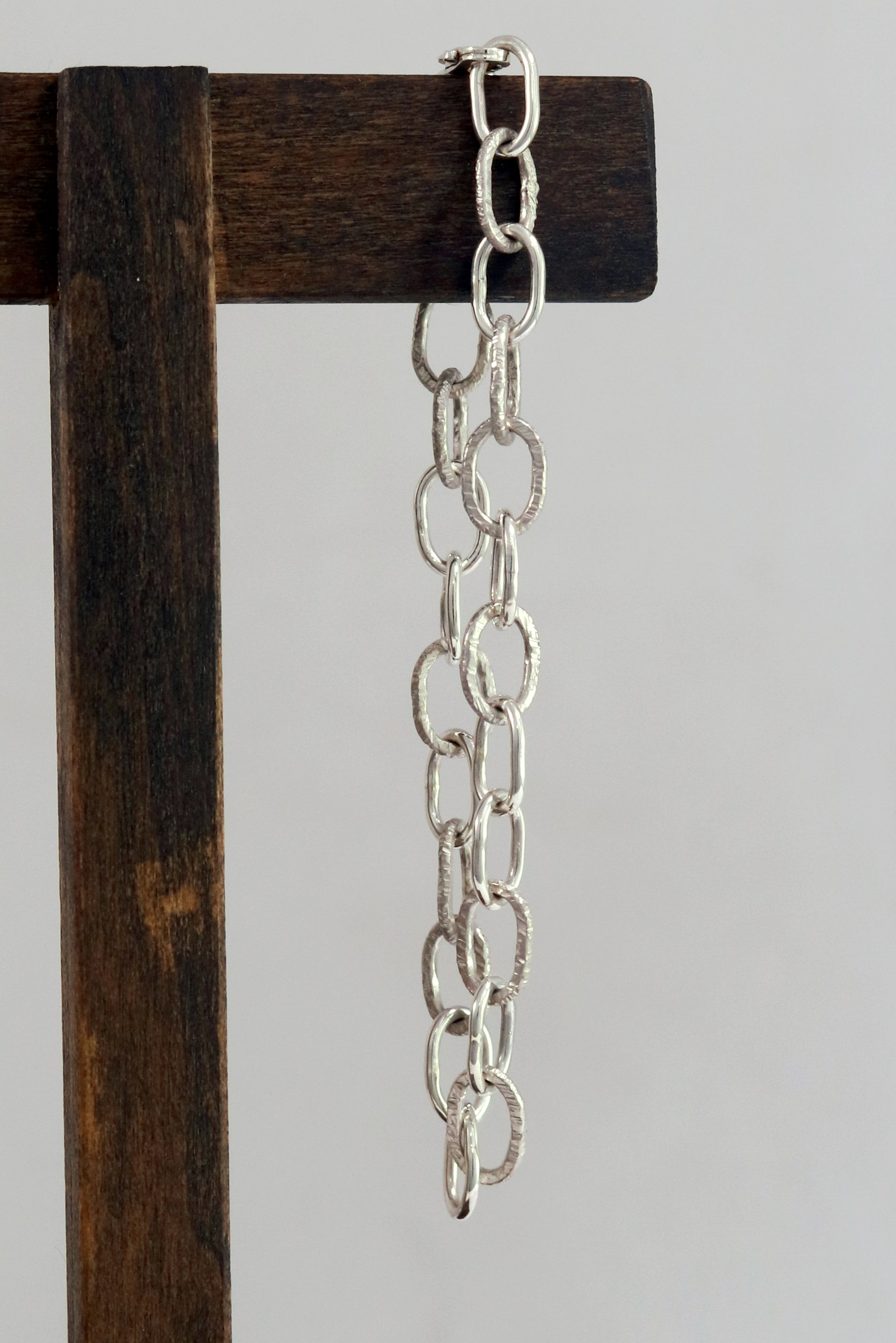 A solid sterling silver oval chain link bracelet mixed polished and textured links.