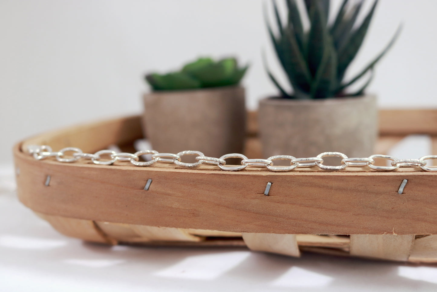 A solid sterling silver oval chain link bracelet mixed polished and textured links.