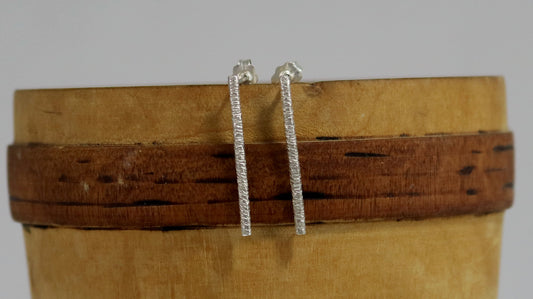 Sterling silver long bar studs with linear texture.