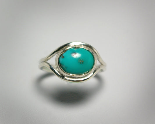 Oval natural gemstone set horizontally in a sterling silver bezel in-between two silver bands that open for the stone.